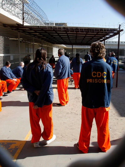 Inmates walk around a recreation yard of a California prison.