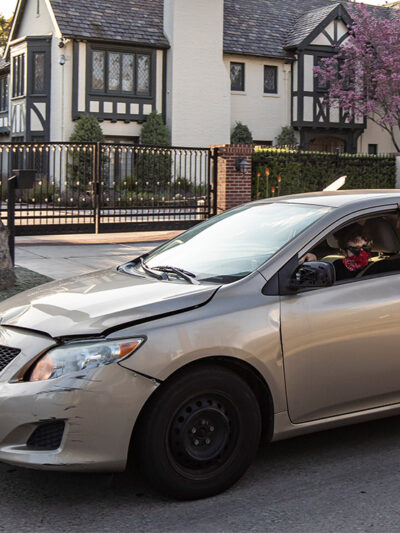 A protestor drives by L.A. Mayor Eric Garcetti's mansion with a sign in favor of extended rent and mortgage protections.