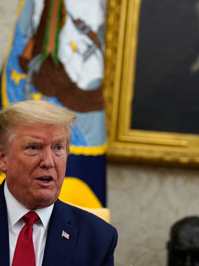 Donald Trump speaking in the Oval Office with a painting of George Washington in the background.