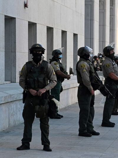 Police force stands guard in riot gear in front of Hall of Justice in Los Angeles.