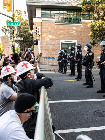 Protestors demonstrate in front of a line of police officers outside of Mission Police Station in San Francisco after the death of George Floyd