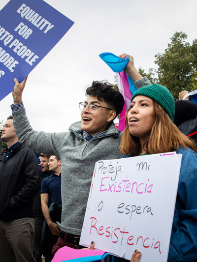 Demonstrators carrying signs advocating for the rights of LGBTQ people.