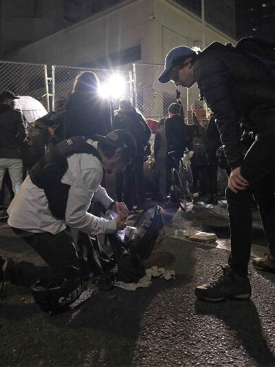 Two journalists prepare for police use of force.