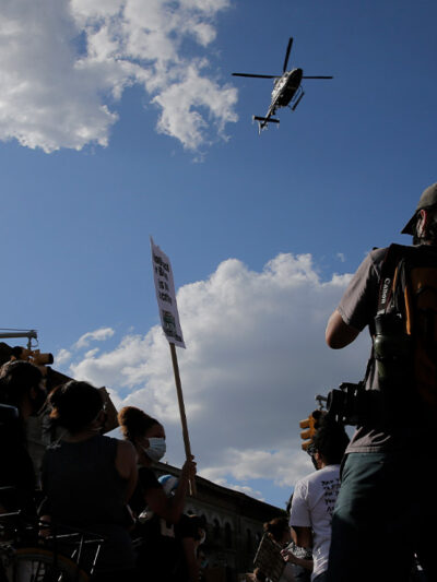 Protestors react to a low flying helicopter during a march in Brooklyn, New York.