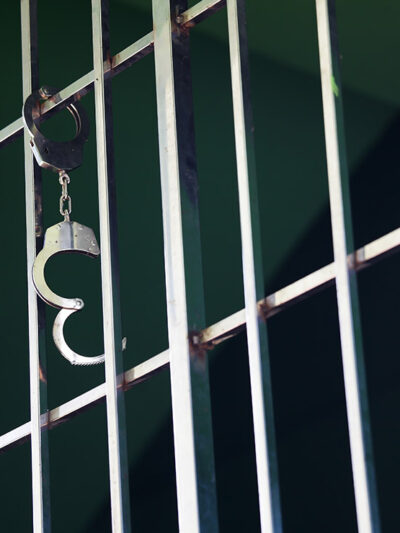 Handcuffs hanging from jail cell.