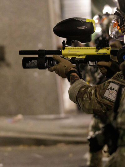 Federal SRT officers shoot less-lethal munitions at protesters.