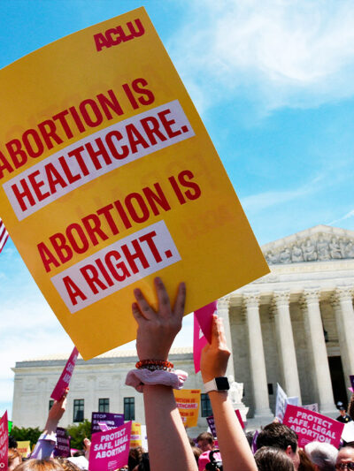 Pro-abortion activist holds ACLU placard that reads "Abortion is healthcare. Abortion is a right." during a rally at the Supreme Court