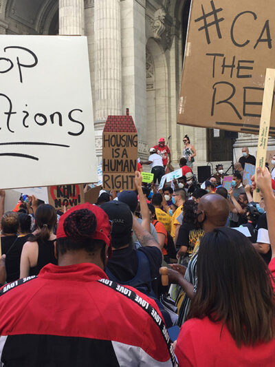 Protesters demonstrating with signs calling for rent relief and an end to evictions.