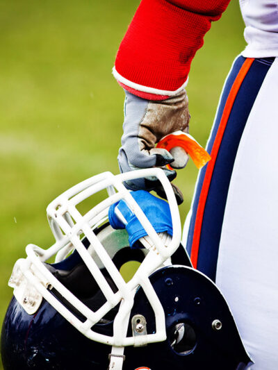 A football helmet in a player's hand.