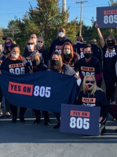 A group of people wearing shirts and carrying banners that read "Yes on 805" referring to Oklahoma's Question 805 on the ballot.