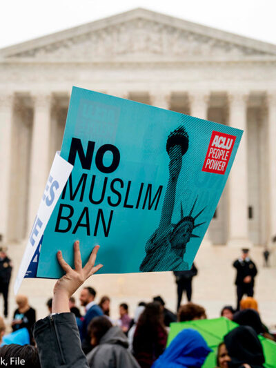 In this April 25, 2018 file photo, a person holds up a sign that reads "No Muslim Ban" during an anti-Muslim ban rally in front of the Supreme Court building in Washington, DC.