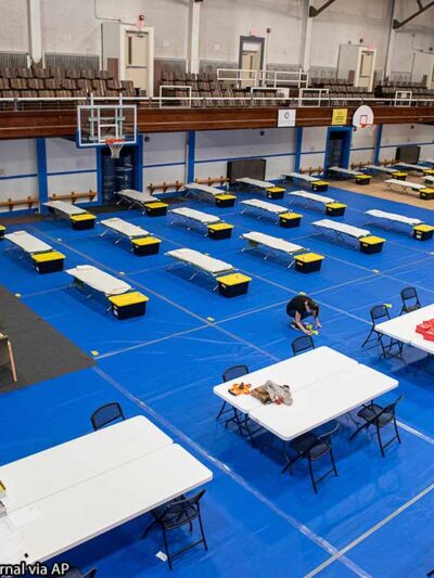 Community Concepts Wellness Shelter Attendant, marks the start of the meal line at the Lewiston Armory, in Lewiston, Maine on Wednesday, April 22, 2020.