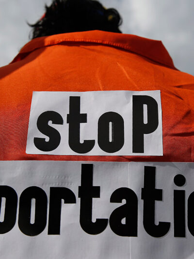 Juan Correa Villalonga wears an orange jumpsuit the says "stop deportations" on the back in protest against the ICE agents deporting Venezuelans.