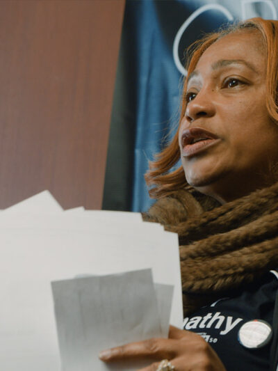 Pamela Winn holding papers in a still from the short film, WINN.