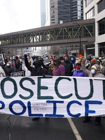 Black Lives Matter protesters stand with a banner that reads "Prosecute Police" to demand justice for Jacob Blake