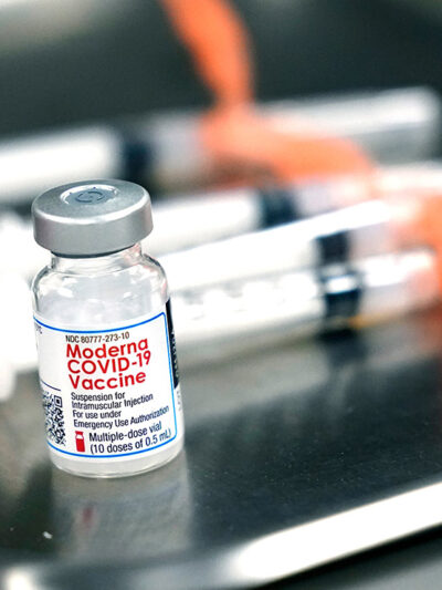 Syringes with doses of the Moderna COVID-19 vaccine on a surgical tray.