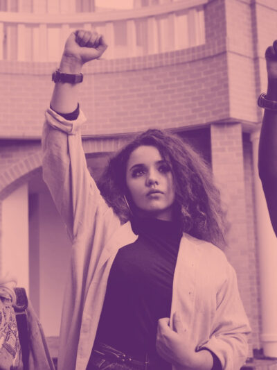 Girls in protest raising fists on pink background