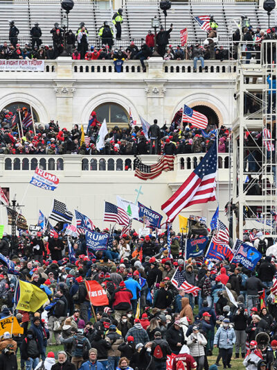Insurrectionists amassing on the steps, walls, balconies, and grounds of the Capitol Building.