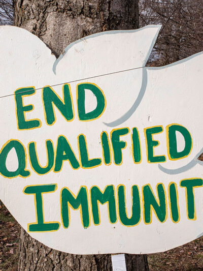 Sign of white dove reading "End Qualified Immunity", Qualified Immunity gives police officers immunity in the court of law given certain circumstances.