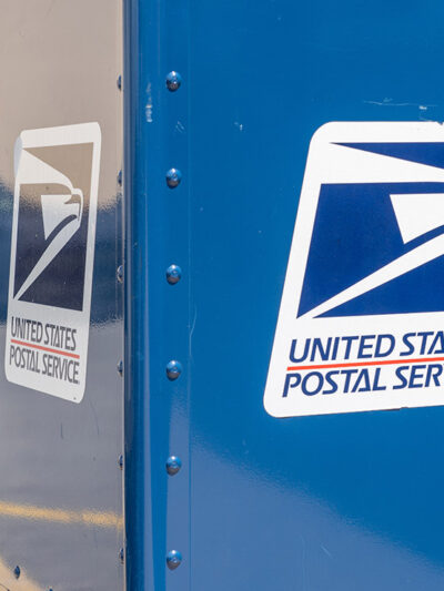 A blue United States Postal Service (USPS) collection box as seen on the street.