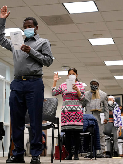 Candidates for American citizenship recite the Oath of Allegiance during a naturalization ceremony.