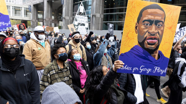 Demonstrators carry signs demanding justice for George Floyd.