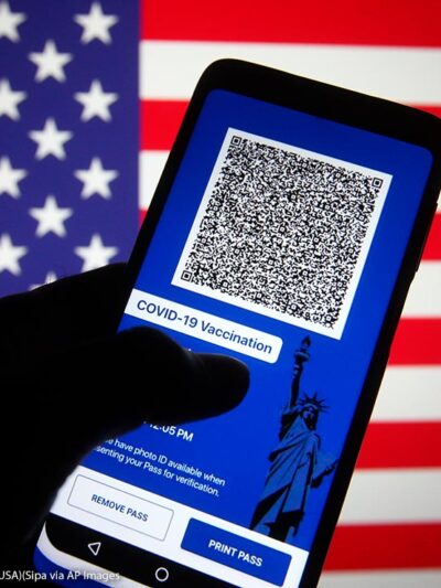 In this photo illustration, Excelsior Pass app which provides digital proof of COVID-19 vaccination or negative test results seen displayed on a smartphone screen in front of the US flag.