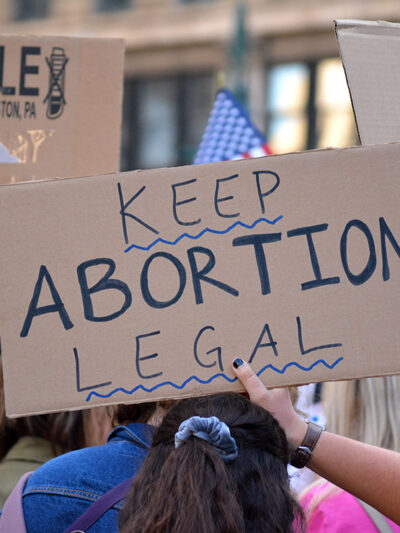 People protesting in support of abortion rights, holding sign that reads "Keep Abortion Legal"