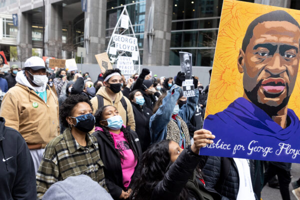 Protestors holding up a portrait of George Floyd