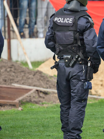 Three police officers in uniform, with "Police" written on the back of their vests.