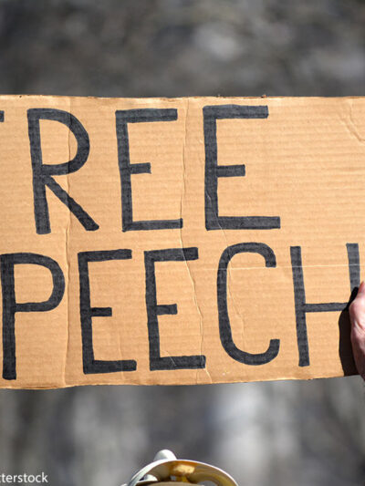 A sign reading FREE SPEECH is held aloft by person protesting immigration laws banning some Muslims at Battery Park in Manhattan in 2017 in New York City