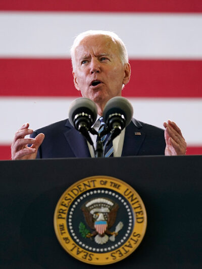 President Joe Biden speaks behind podium to American service members in England