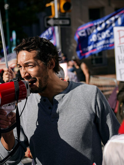 A man uses a bullhorn as he demonstrates with supporters of Donald Trump outside the Pennsylvania Convention Center 
