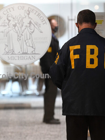 An FBI employee guards the entrance doors to the Detroit City Council on the 13th floor of the Coleman A. Young Municipal Center, Thursday, Aug. 25, 2021, in Detroit.