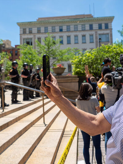 Man recording a line of police people