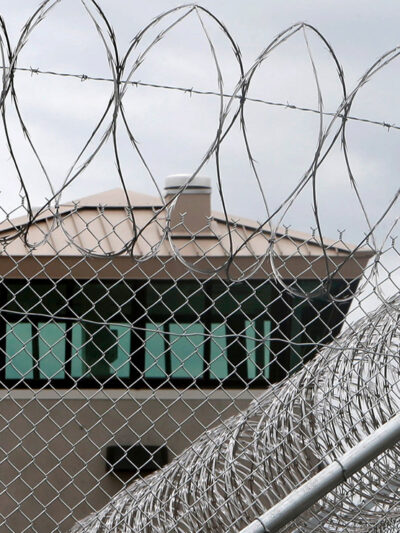 A guard tower over the fence at a correctional health care facility.