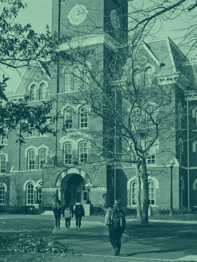 Green tinted picture of students walking on a college campus.