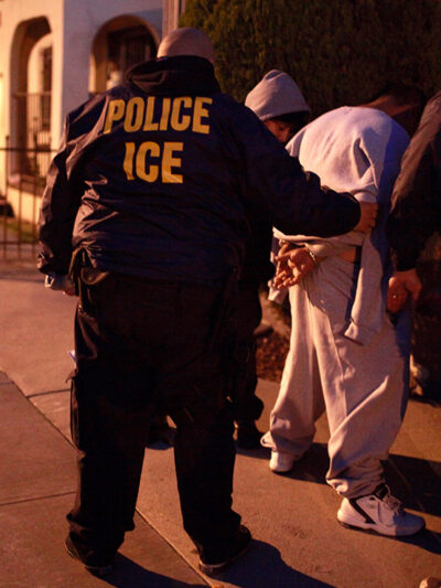 U.S. Immigration and Customs Enforcement (ICE) officers apprehending two men.