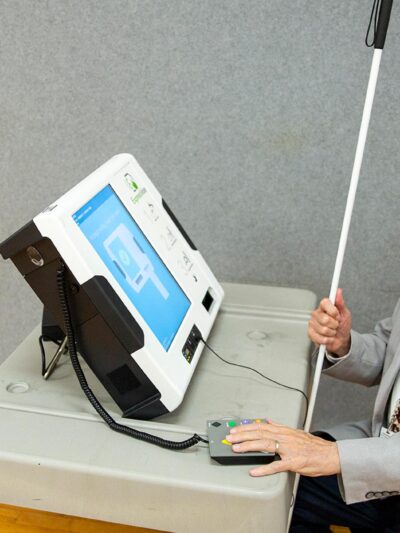 Michael Kasey, who is blind, demonstrates a voting machine that allows people with disabilities to vote.