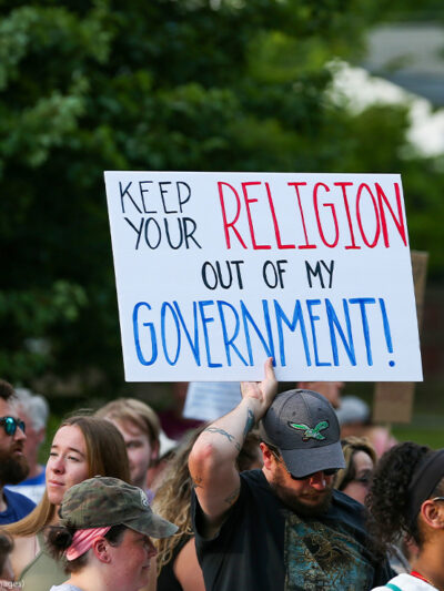 A protestor holds a sign reading "Keep Your Religion Out of My Government" during a rally at Memorial Park in Danville, Pennsylvania.