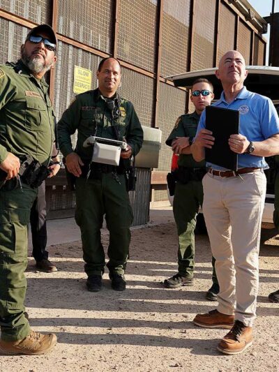 Homeland Security Secretary Alejandro Mayorkas, second from right, looks up along with U.S Border Patrol agents as a drone flies overhead as he tours a section of the border wall Tuesday, May 17, 2022, in Hidalgo, Texas.