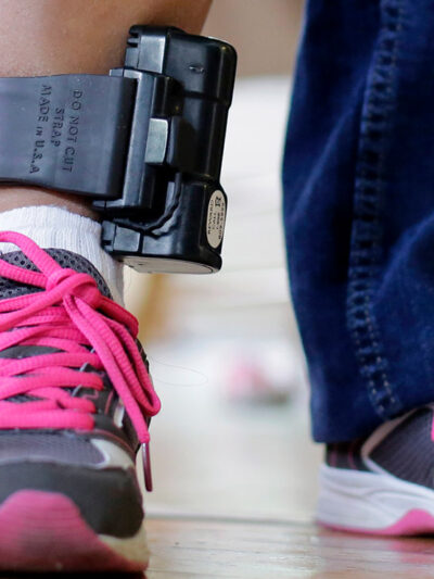 An individual wearing an ankle monitor.