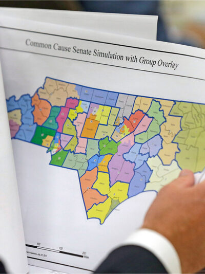An elected official reviews a map of North Carolina districts at select committee meeting on redistricting.