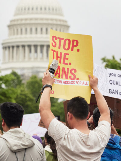 A group of people holding reproductive rights signs in front of the Capitol Building.