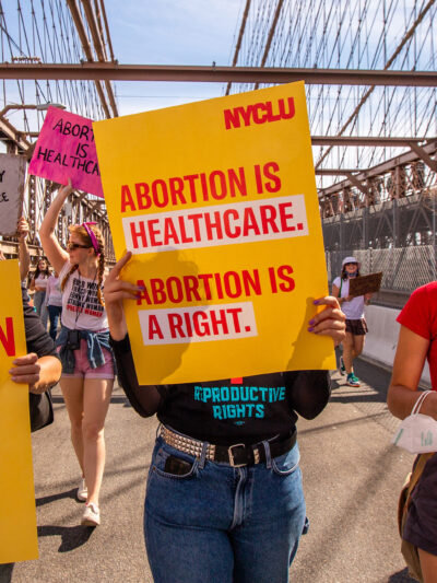 Three demonstrators holding pro-abortion signage.