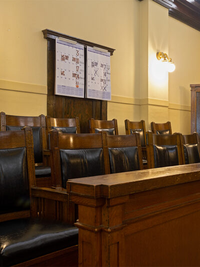 An empty jury box with leather and wood chairs.