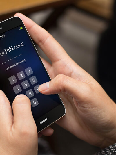 A person trying to enter security pin code on a cell phone screen.