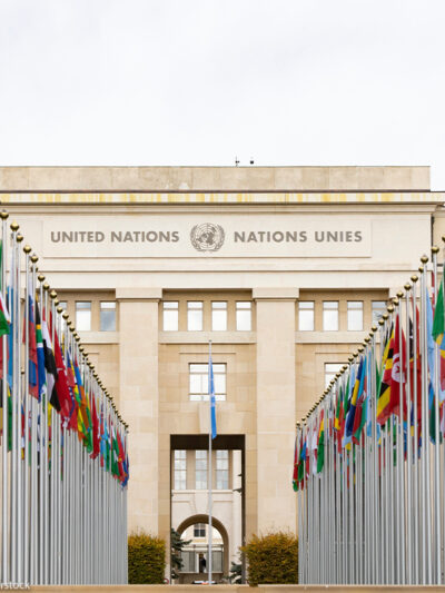 International flags flying in front of the Geneva office of the United Nations.