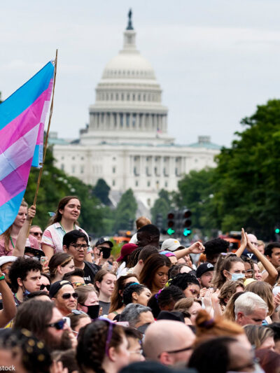 Trans flag flown at Capital Pride parade in Washington, DC, with the US Capitol in the background.