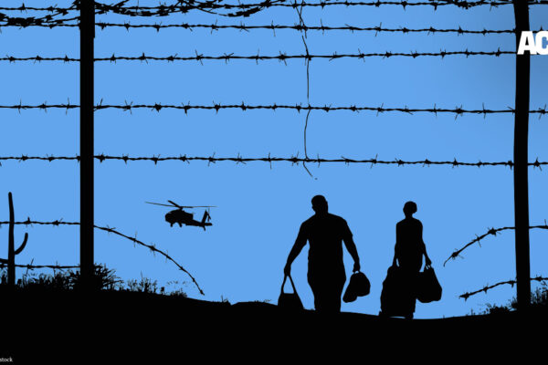 Fence with spikes and helicopter at immigration detention center.